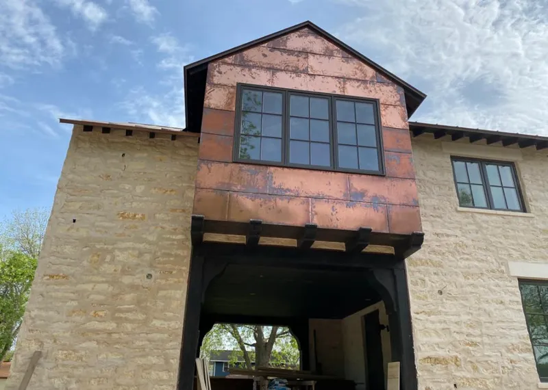 Copper metal panel facade on a stone building for Roof Repair in Williams