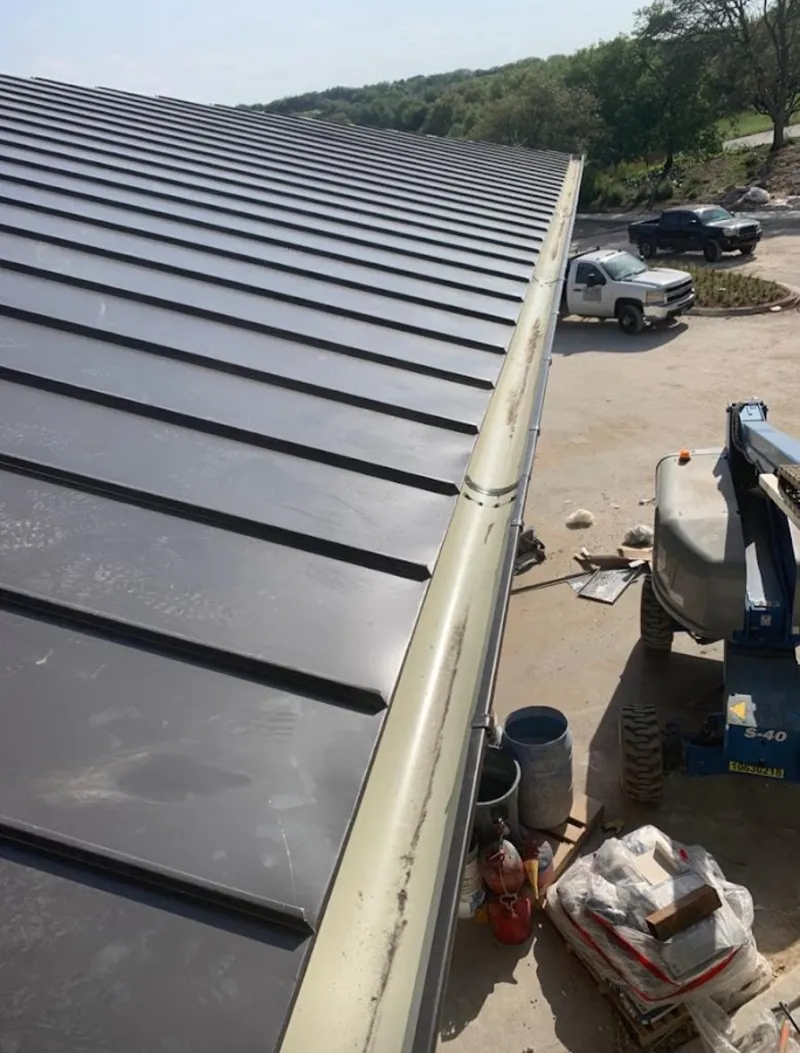 Standing seam panel and gutter detail on a metal roofing jobsite in Williams